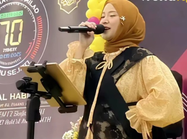 Nisa Sabyan saat tampil di sebuah acara dengan baju gombrong yang menghadirkan spekulasi akan kehamilannya. [Instagram]